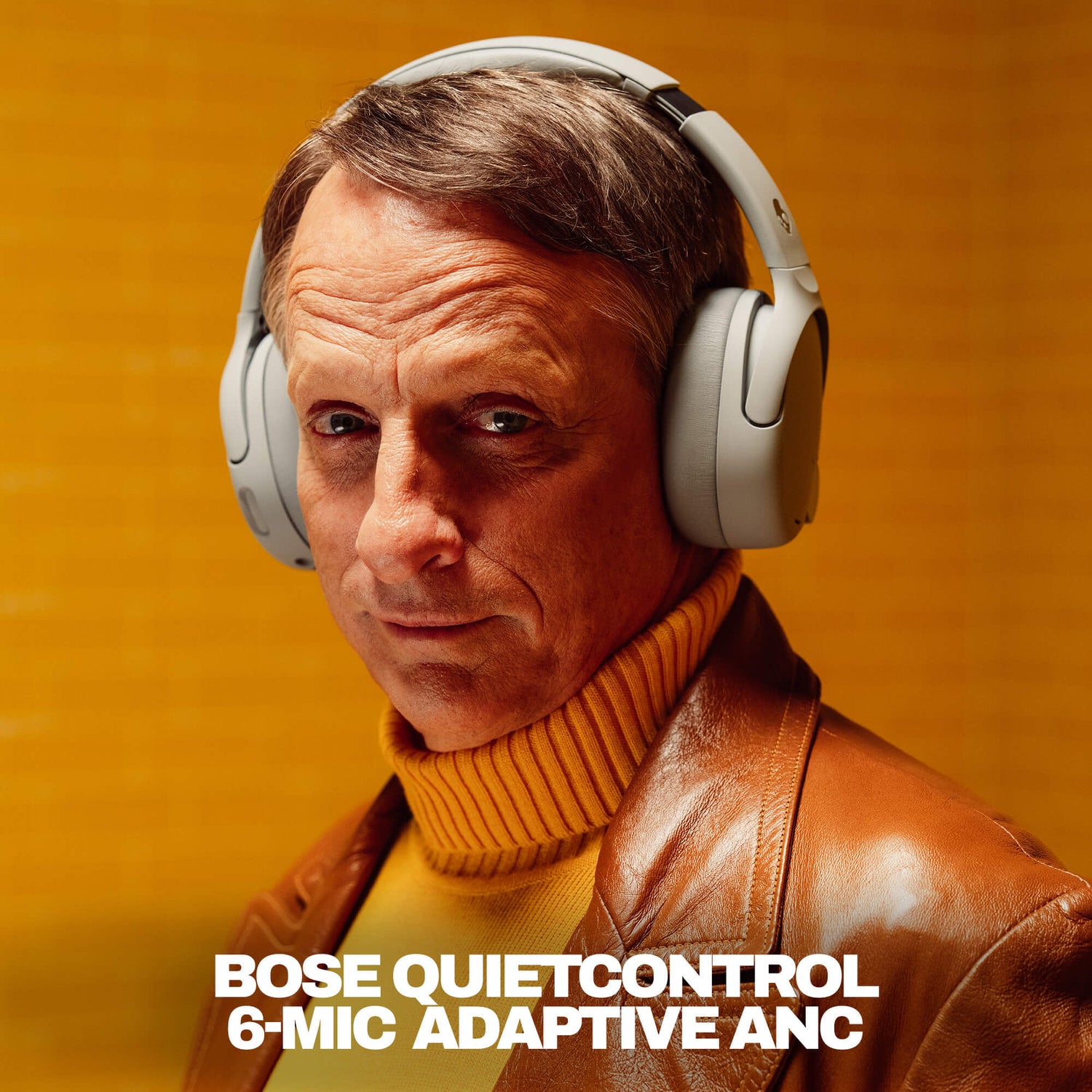 Tony hawk wearing Skullcandy Crusher 1080 with Bose QuietControl with a warm background | Cement