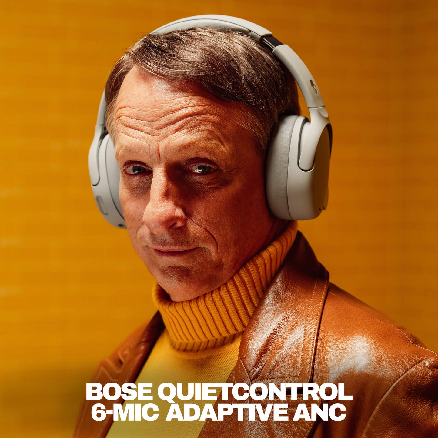 Tony hawk wearing Skullcandy Crusher 1080 with Bose QuietControl with a warm background | Cement