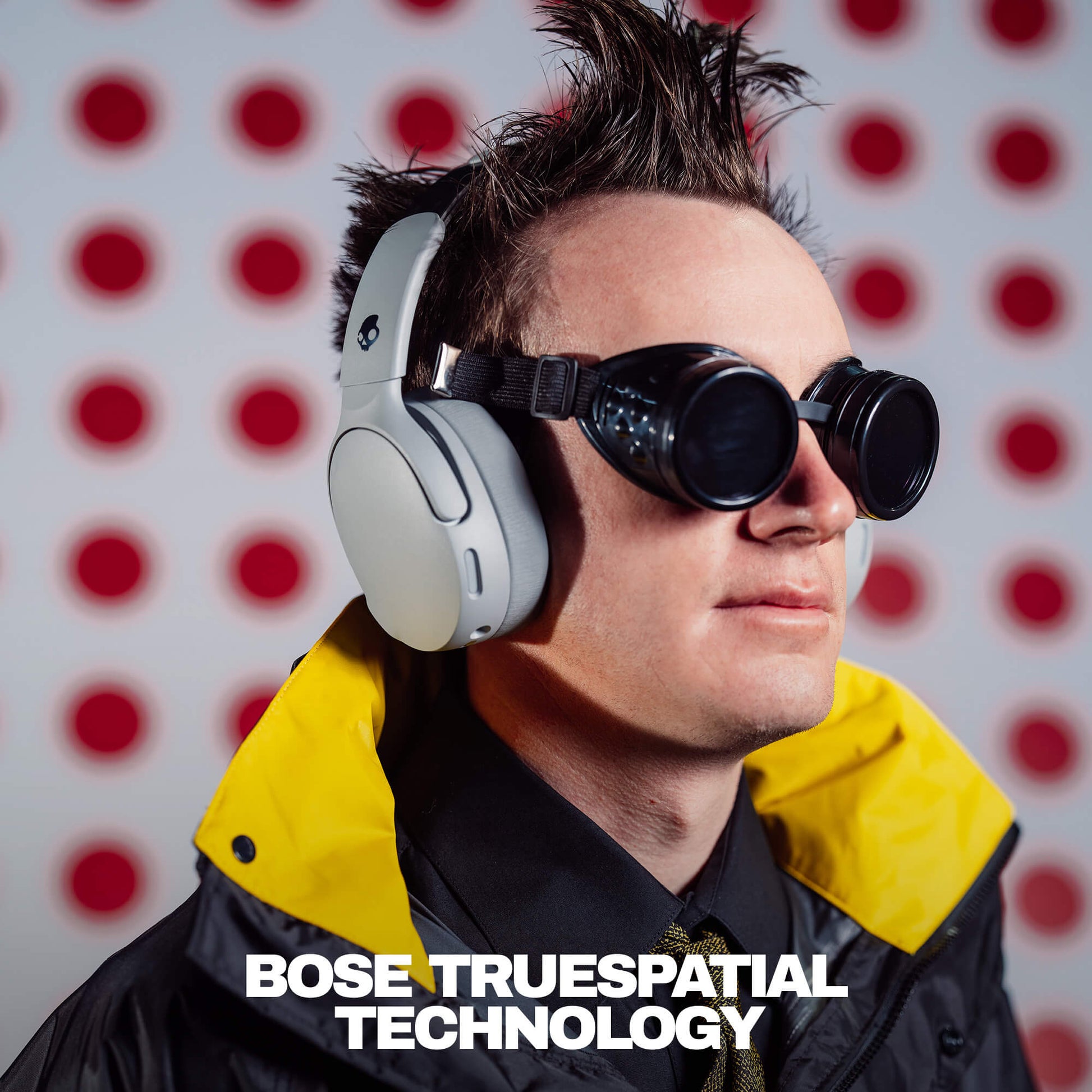 Person wearing Crusher 1080 and goggles with 'Bose TrueSpacial Technology' text against a red and white polka dot background. | Cement
