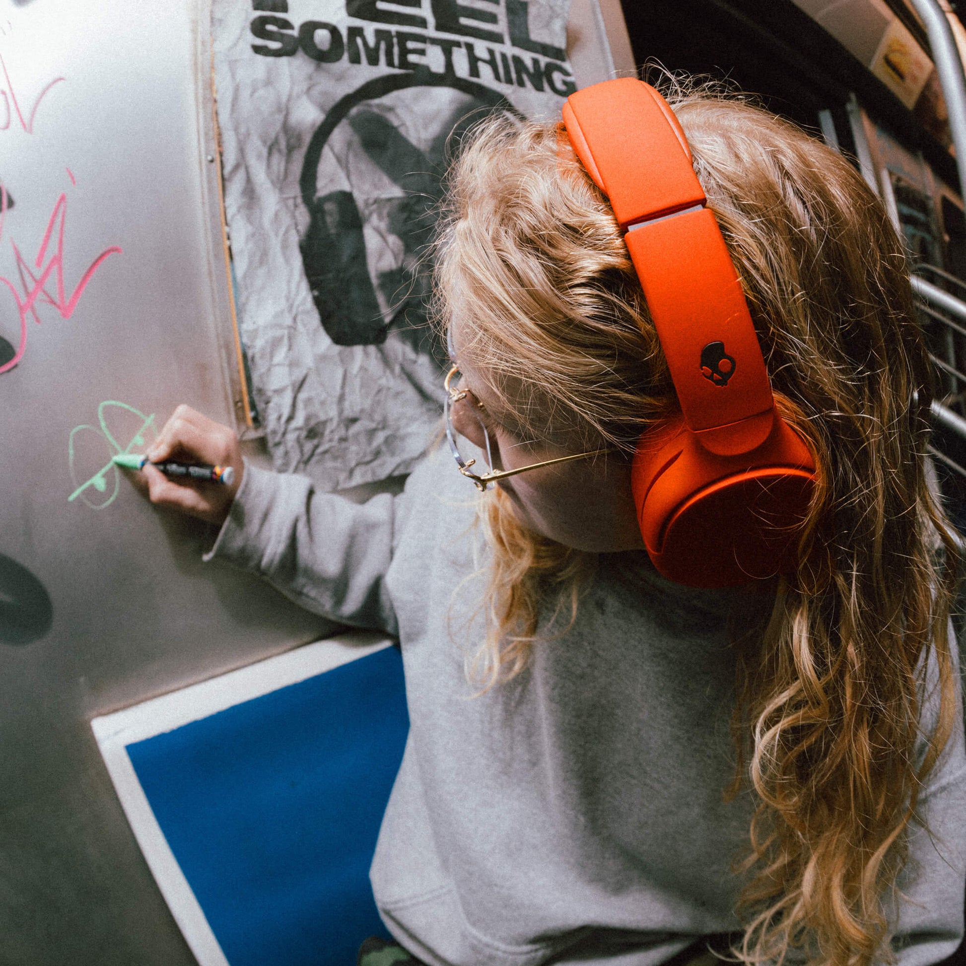 Person wearing red Crusher 720 writing on a whiteboard with a graphic design in the background. | Plasma