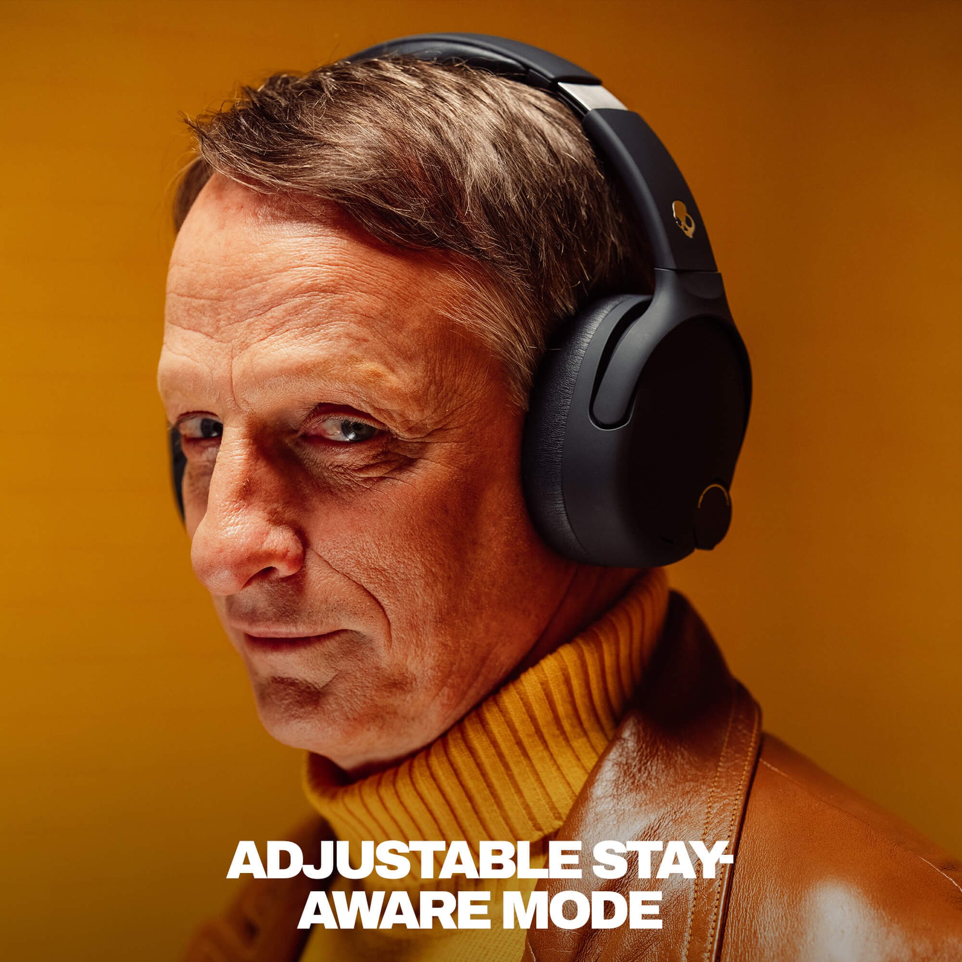 Tony Hawk wearing black cruhser 720 with text 'Adjustable Stay Aware Mode' on a warm-toned background | True Black