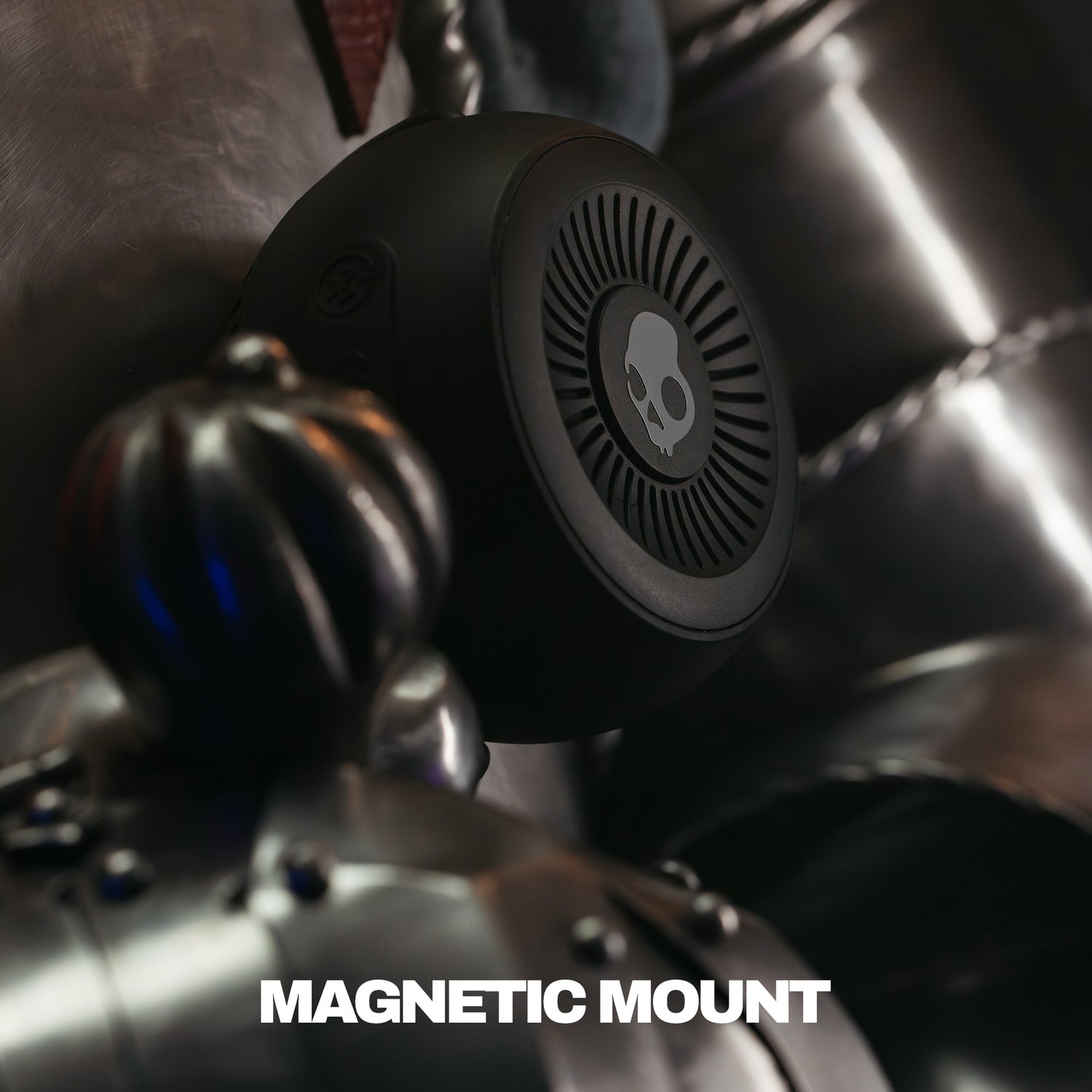 Close-up of a motorcycle with a speaker magnetic mount attached, featuring a brand logo. | True Black