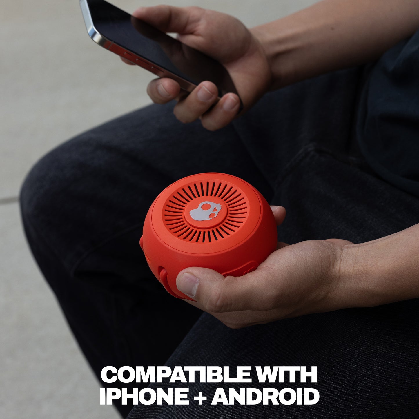 Person holding a red portable speaker and smartphone, with text indicating compatibility with iPhone and Android. | Plasma