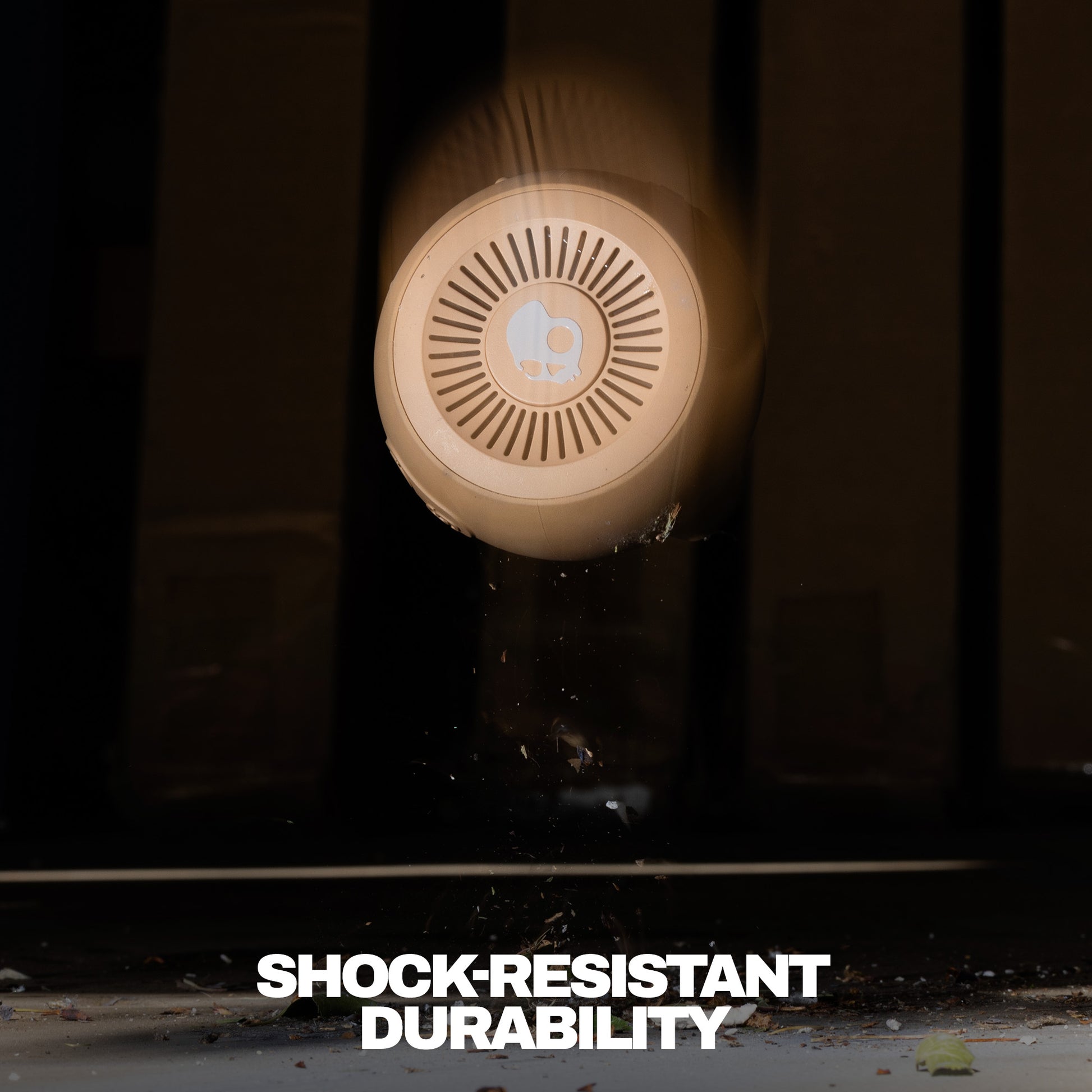 Round shockproof speaker with 'Shock-Resistant Durability' text on a dark background | Primer