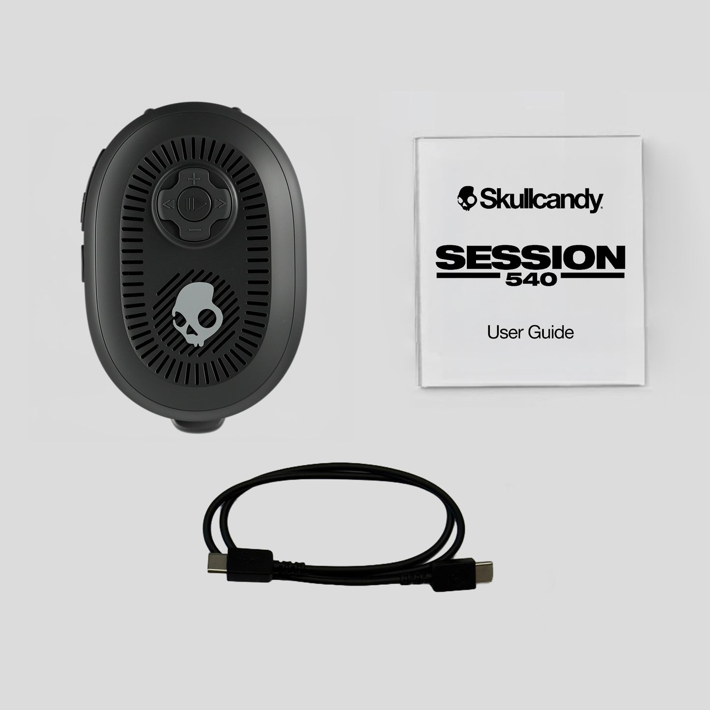 Black speaker with cable and Skullcandy user guide on a light gray background | True Black